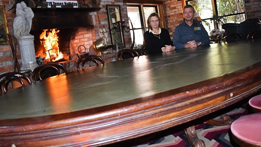 Robert and Therese Fenwick sit around what they claim to be 'Queensland's oldest relic', a table used by politicians from 1860 onward. Picture: Matthew Purcell