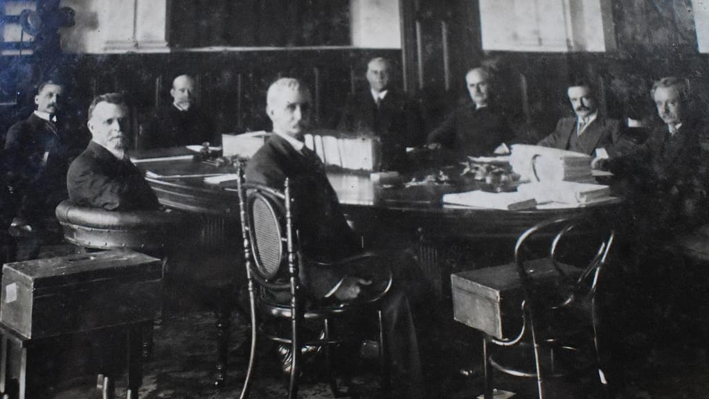 Queensland political dignitaries, including the Premier and Governor, sit around the table in 1914.